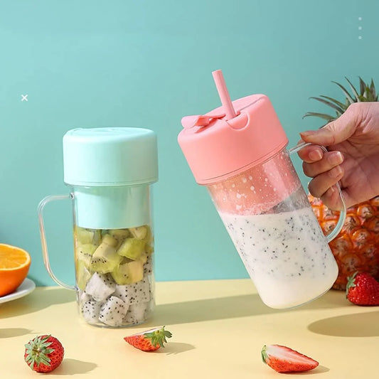 Portable mini blender bottle in mint and pink colors with fresh fruit inside.